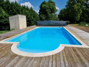 a pool on a wooden deck with a bench on top at Amazonite - 6 à 8 couchages in Archigny