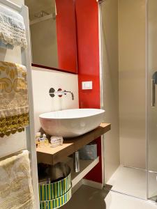 uma casa de banho com um lavatório branco e paredes vermelhas em La Torre em Florença