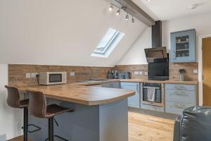 cocina con armarios azules y encimera con microondas en Abbey Apartments Modern ApartHotel for Tourists & Professionals, en Barrow-in-Furness