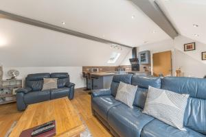 sala de estar con sofá de cuero azul y mesa en Abbey Apartments Modern ApartHotel for Tourists & Professionals, en Barrow-in-Furness
