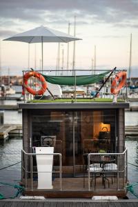 a boat with a table and chairs and an umbrella at The Homeboat Company Sant'Elmo-Cagliari in Cagliari