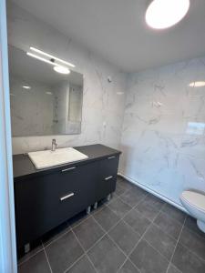 y baño con lavabo, espejo y aseo. en HOTEL LES PORTES DE PARIS en Ivry-sur-Seine