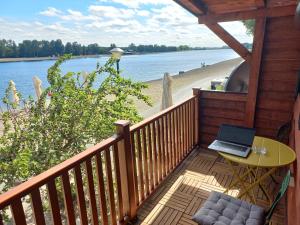 a balcony with a table and a laptop on the beach at Island Ada in Čukarica