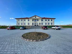 a large white building with cars parked in a parking lot at MAGURSKA PANORAMA l samodzielne zameldowanie l self check-in in Chrząstówka