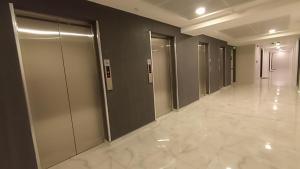 einen Flur mit Aufzügen in einem Gebäude in der Unterkunft 19th Floor Sunset Secure Condo with Pool & Fitness & Parking included in price in Skopje