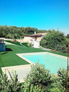 a large swimming pool in a yard with green grass at B&B Badde Tale in Ossi