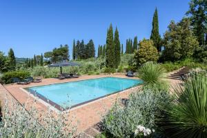 una piscina en un jardín con árboles en Villa San Gimignano View, en Strada