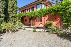 una casa roja con un jardín delante en Villa San Gimignano View, en Strada