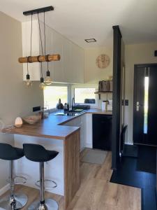 a kitchen with a counter and stools in it at Domek u Zająca in Krynica Zdrój