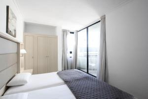 阿德耶LaBranda Suites Fanabe的一间带床和窗户的白色卧室