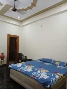 a bedroom with a bed with a blue comforter at Haridwar Homestay in Haridwār