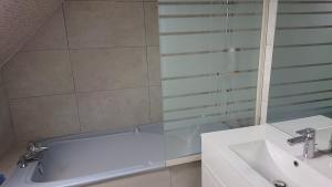 a bathroom with a white tub and a sink at Appartement Duplex 55m2 face à la mer in Luc-sur-Mer +7 photos