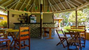 restauracja z drewnianymi stołami i krzesłami oraz blatem w obiekcie Recanto 3ELLL w mieście Bodoquena