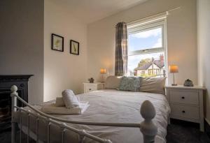 a bedroom with a large bed and a window at Spacious Town House in Lytham St Annes