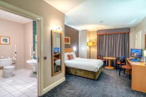 una camera d'albergo con letto e bagno di City Hotel a Londonderry