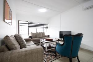 a living room with a couch and a chair at Safi Luxury Apartment 6 - 2 bedroom in East London
