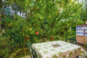 een tafel en stoelen in een tuin met een boom bij One bedroom house with sea view enclosed garden and wifi at Sorrento 1 km away from the beach in Sorrento