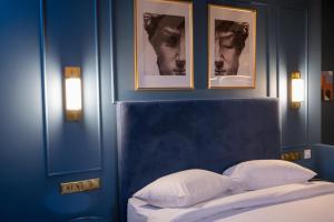 una camera da letto con una parete blu e immagini sopra un letto di L Suites The Writer's House a Gythio