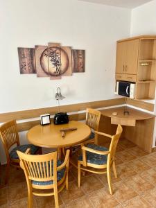 a dining room with a table and chairs at Hortenzia Apartman in Balatonlelle +3 photos