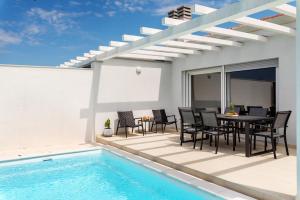 a patio with a table and chairs next to a swimming pool at Umag-Kuća za odmor Sandra in Umag