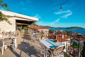 a balcony with tables and chairs and a view of the water at Yoga House Kaş in Kaş