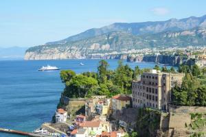 een uitzicht op de kust van Amalfi met een cruiseschip bij One bedroom apartement with sea view enclosed garden and wifi at Sorrento 1 km away from the beach in Sorrento