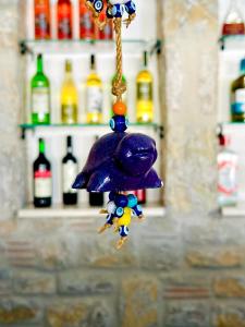 a toy monkey hanging from a rope with bottles in the background at Villa Anfora in Datca