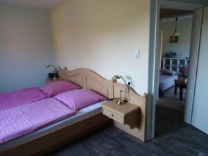 een slaapkamer met een bed met paarse lakens en een spiegel bij Zur-Kirsche in Nahrendorf