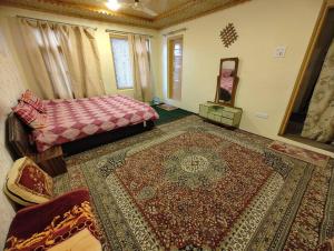 a room with a bed and a rug on the floor at Green House with kitchen in Srinagar +43 photos