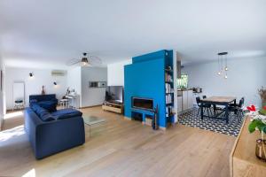 a living room with a blue couch and a table at Villa Ycee Ondo in Roquefort-les-Pins