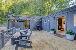 a blue tiny house with a wooden deck at Couples Retreat: King Bed:Hot tub:Firepit & More in Blue Ridge