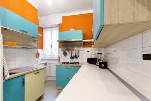 a kitchen with blue cabinets and orange walls at Giardino Sul Mare in Bogliasco +15 photos