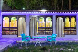 einen Tisch und Stühle vor einem Gebäude mit Beleuchtung in der Unterkunft Ghanchi Inn Hotel in Dargai
