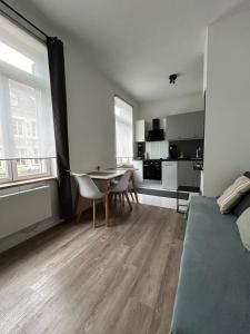 1 dormitorio con cama, mesa y cocina en Charmant T2 centre ville, en Givet