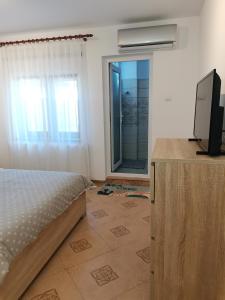 1 dormitorio con 1 cama, TV y espejo en Miri's House, en Eforie Sud
