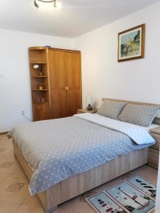 1 dormitorio con 1 cama y armario de madera en Miri's House, en Eforie Sud