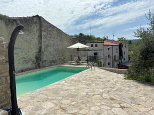 a swimming pool with an umbrella next to a building at Casa Ripa in Ripabottoni