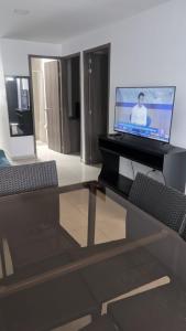 a living room with a glass table and a television at Acogedor apartamento La Nubia in Manizales