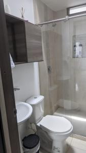 y baño con aseo, lavabo y ducha. en Acogedor apartamento La Nubia en Manizales