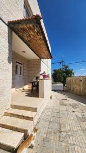 a cat sitting on the steps of a house at Blackbird Sanctuary homestay & Art Cafe in Ajloun