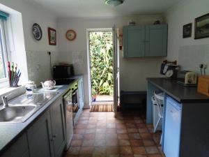 a kitchen with a sink and a counter top at Jordan Cottage in Fowey +10 photos