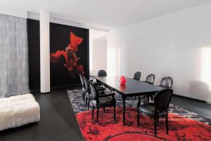 a dining room with a black table and chairs at Kameha Grand Bonn in Bonn