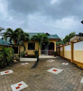 a house with palm trees in front of it at Queen Elizabeth Apartment in Dar es Salaam