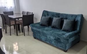 a living room with a blue couch and a table at Acogedor apartamento La Nubia in Manizales