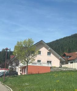 a white house with a tree in a yard at Angelina in Baiersbronn