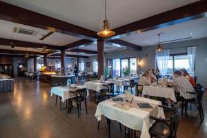 un restaurante con mesas blancas y gente sentada en ellas en Hotel Nautica - Wellness & SPA, Free parking, Pet friendly, en Novigrad Istria
