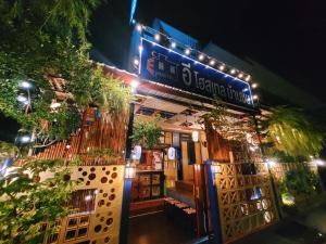 Restauracja z tabliczką na przedniej stronie w nocy w obiekcie อีโฮสเทลบ้านช่น w mieście Ban Chak Khamin