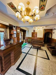 een grote woonkamer met een kroonluchter en een open haard bij Hotel Avalanche in Shimla