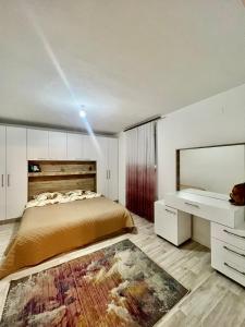 a bedroom with a large bed and a large rug at July Apartment in Peje