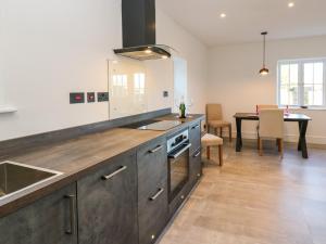 a large kitchen with a sink and a table at Luham Cottage in Penrith